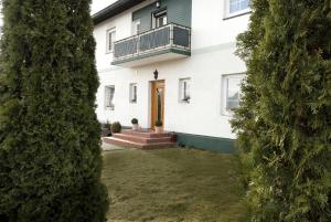 a view of a house through two trees at Urlaubsapartment am Silbersee in Villach