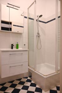 ein weißes Badezimmer mit Dusche und Schachbrettboden in der Unterkunft Highlight Apartment St Charles Church in Wien + 10 Fotos