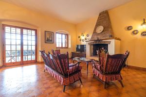 a living room with chairs and a fireplace at Villa Medina - Goelba in Porto Azzurro