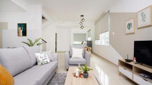 ein Wohnzimmer mit einem Sofa und einem TV in der Unterkunft Desaru Minimalism Muji Style by Joyfully 35M7 in Desaru