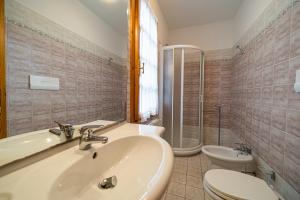 a bathroom with a sink and a toilet and a shower at Villa Medina - Goelba in Porto Azzurro +32 photos