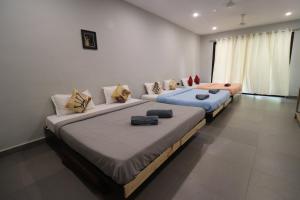 2 Betten in einem Zimmer mit Sofa in der Unterkunft Aroma boutique villa by 29 Bungalow in Nagaon