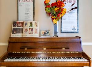 a piano with a vase of flowers and pictures at Opera Boutique B&B in Florence