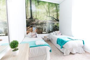 zwei Betten in einem Zimmer mit einem Gemälde an der Wand in der Unterkunft Vázquez de Mella Gran Vía in Madrid