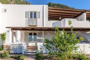 a white house with a hill in the background at LE CASETTE DI MALFA in Malfa