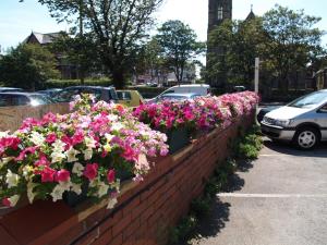 a brick retaining wall with pink and white flowers at The Hollingworth in Lytham St Annes