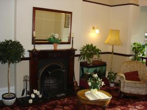 a living room with a fireplace and a mirror at The Hollingworth in Lytham St Annes