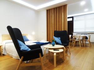 een slaapkamer met een bed, twee stoelen en een tafel bij VUT San Cristóbal LARANITASALAMANTINA in Salamanca