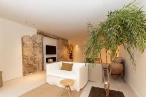 a living room with a white chair and a plant at Hotel Avenida in Zaragoza