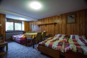 コシチェリスコにあるWilla Fantazjaのベッドルーム1室(ベッド2台、テーブル、椅子付)