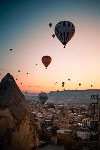 grupa balonów latających nad miastem w obiekcie Antique Terrace Cave Suites w Göreme