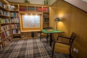een bibliotheek met een bureau, een raam en boekenplanken bij Castletown Hotel in Castletown