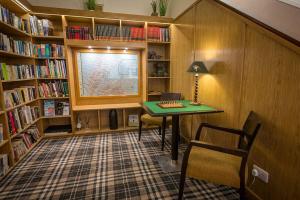 a library with a desk and a window and book shelves at Castletown Hotel in Castletown