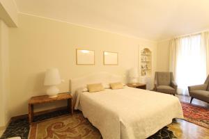 een witte slaapkamer met een bed en een stoel bij B&B Carlo Alberto in Turijn