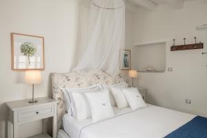 a white bed with a white comforter and pillows at Four Seasons Hydra Luxury Suites in Hydra