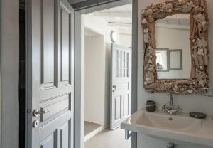 a bathroom with a mirror, sink, and bathtub at Four Seasons Hydra Luxury Suites in Hydra