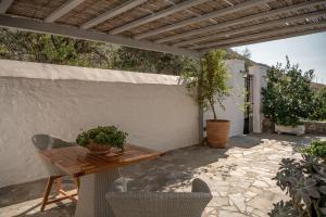 an outdoor patio with a wooden table and chairs at Four Seasons Hydra Luxury Suites in Hydra