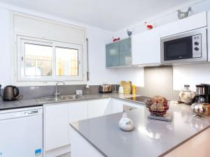 a kitchen with white cabinets and a counter top at Holiday Home Isis by Interhome in L'Escala