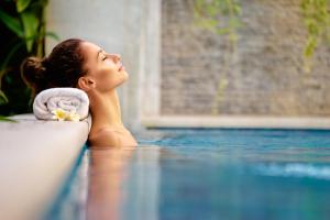 a woman laying on the floor next to a swimming pool at Principe Alogna Hotel & SPA in Altavilla Milicia