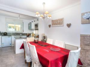 a kitchen and dining room with a red table and chairs at Holiday Home Isis by Interhome in L'Escala