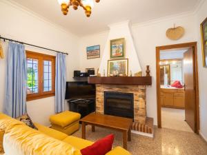 a living room with a fireplace and a yellow couch at Holiday Home Can Toni Mari by Interhome in Sant Carles de Peralta