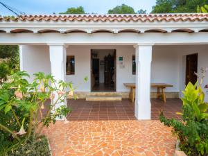 Biały dom z ceglanym patio w obiekcie Holiday Home Can Toni Mari by Interhome w mieście Sant Carles de Peralta