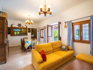 ein Wohnzimmer mit einem gelben Sofa und einem Esszimmer in der Unterkunft Holiday Home Can Toni Mari by Interhome in Sant Carles de Peralta