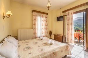 a bedroom with a bed and a large window at Rizoma Guesthouse in Mikro Chorio