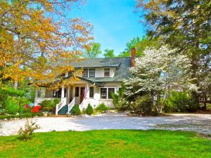 a white house with a yard with trees at Oakland Cottage Bed and Breakfast in Asheville