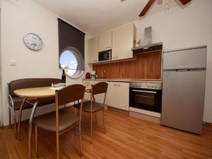 uma cozinha com uma mesa e cadeiras e um frigorífico em Apartment Anđa-3 by Interhome em Trogir