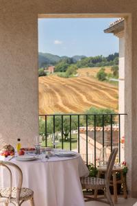 a table with wine glasses and a view of a field at Can Alemany in Santa Margarita de Mombúy