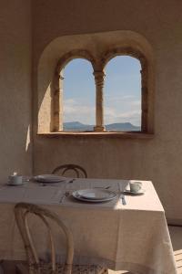 a table with chairs and a table with two windows at Can Alemany in Santa Margarita de Mombúy