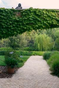 a brick path in a garden with a green hedge at Can Alemany in Santa Margarita de Mombúy