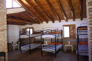 a room with several bunk beds in a building at La Dehesa Boyal in Los Yébenes