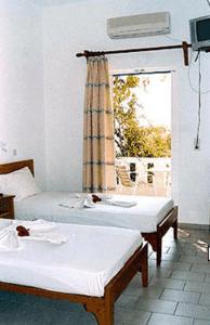 a room with two beds and a window at Pension Irene in Ios Chora