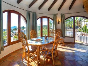 a dining room with a table and chairs and windows at Holiday Home Roberto by Interhome in Pedramala