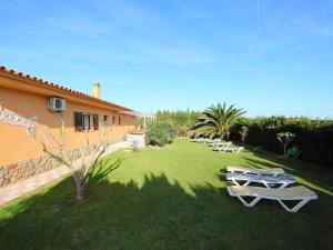 una fila de tumbonas en un césped junto a una casa en Holiday Home Don Felipe by Interhome en Sant Martí d’Empúries