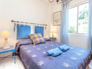 a bedroom with a bed with two blue pillows on it at Apartment L'Olivar II by Interhome in Llança