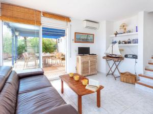 a living room with a couch and a table at Apartment L'Olivar II by Interhome in Llança