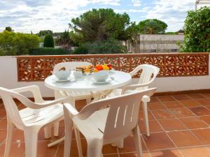 - une table et des chaises blanches sur la terrasse dans l'établissement Apartment Anfora 9 by Interhome, à Sant Martí d’Empúries