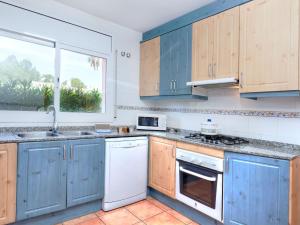 Les tres CalesにあるVilla Villa Cala Nova A by Interhomeの青いキャビネットと窓付きのキッチン