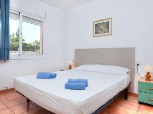 Les tres CalesにあるVilla Villa Cala Nova A by Interhomeのベッドルーム(青い枕を使用した大きな白いベッド付)