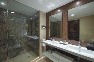 a bathroom with a shower and a sink and a mirror at Riu Palace Cabo San Lucas - All Inclusive in Cabo San Lucas