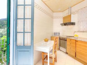 a kitchen with a white table and a window at Apartment La Rectoria II by Interhome in La Vall de Santa Creu