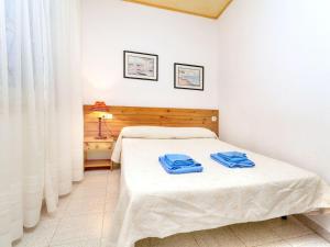 sypialnia z łóżkiem z dwoma niebieskimi ręcznikami w obiekcie Apartment La Rectoria II by Interhome w mieście La Vall de Santa Creu