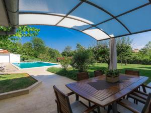 a patio with a table and chairs and a pool at Holiday Home Tijan - ROJ411 by Interhome in Žminj