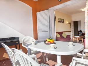 a white table with chairs and a bowl of fruit on it at Apartment La Tuna 6 by Interhome in Sant Martí d'Empúries