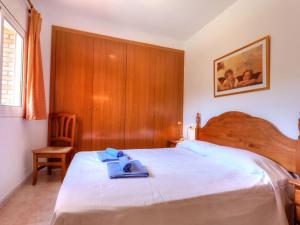 Un dormitorio con una cama con un par de zapatos. en Apartment Cap Ras II by Interhome en Llança