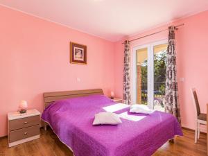 a bedroom with a purple bed and a window at Holiday Home Lara by Interhome in Vrsar