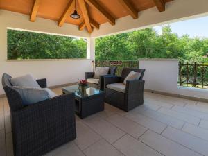 a patio with wicker chairs and a table at Holiday Home Tijan - ROJ411 by Interhome in Žminj